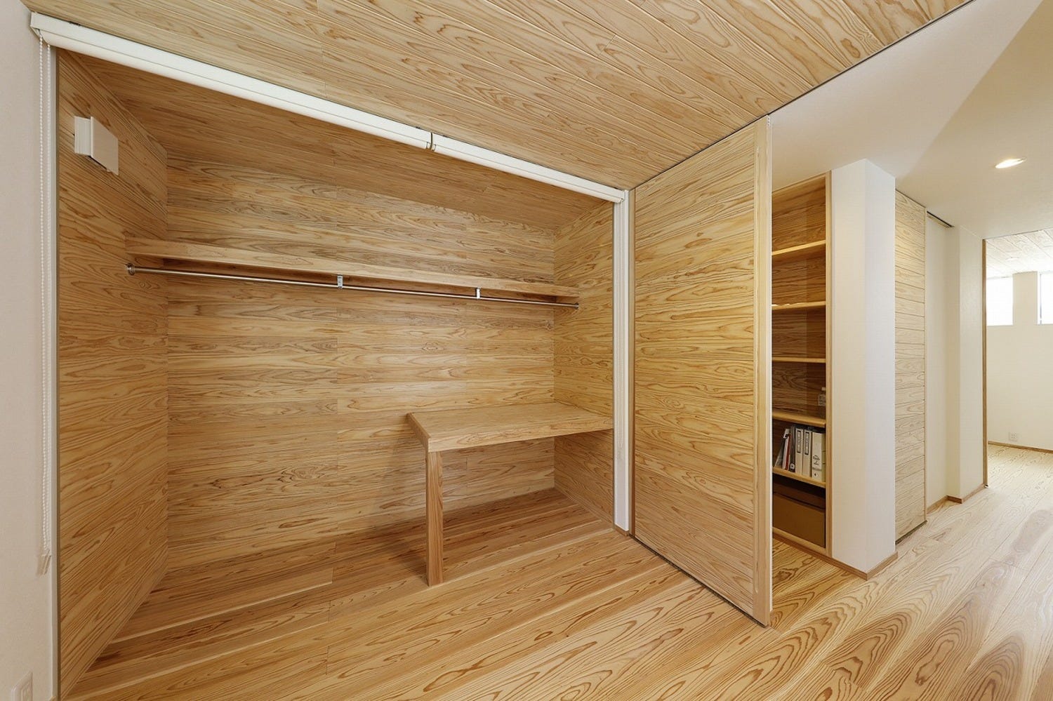 寝室の収納は、あえて扉を付けずにオープンな使い方を。扉を付けるよりも部屋が広く感じます。
ロールススクリーンが設置されていて、たまに閉める感じになります。
部屋と一体感を持たせるために、同じ木目調です。
造作建具のデスクを設置。棚にもなりますが、家事や仕事の作業台にもなります。