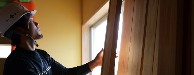 住まいずがこだわっているのは"地元の木を使う"こと。やはり地元の気候風土の中で育った木が、その地の建物を建てるのに最も適していると考えているからです。
第一せっかく地元に良い木があるのに、使わないのはもったいないですよね。
地元の木を使えば運搬費も抑えられますし、車から出るCO2も削減できます。
何より適度に伐採することで、森に光と風が入り、山が健康になるという利点があります。

施工の際には、木の自然な地色をどのように活かすかが大工の腕の見せどころ。自然界のものだけに一つ一つの材の色味はそれぞれ異なります。
一本の木でも芯に近い方は赤く、周縁は白っぽいため、板に挽くと微妙なグラデーションが生まれるのです。
それらを上手に組み合わせながら、全体を見た時にすっきりとまとまるようにつくることが大切です。
それは大工にとって生みの苦しみであると同時に、大きなやりがいでもあります。