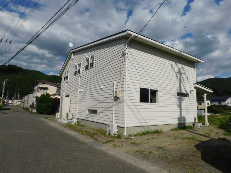 青空に映えるオシャレな白い家