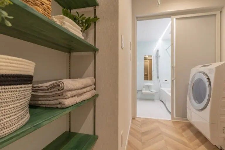 脱衣室に、グリーンの棚板が素敵な可動棚を造作。
ヘリンボーンの床もおしゃれです。