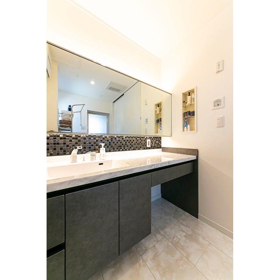 機能的でデザインも美しい洗面化粧台。
鏡との間のタイルも色や柄にこだわって選んだ