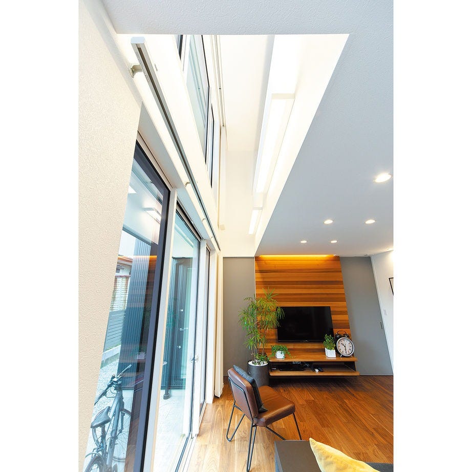 リビングの窓際に設けた吹抜け。光が満ち、空気の通り道にもなり、開放感も高められる