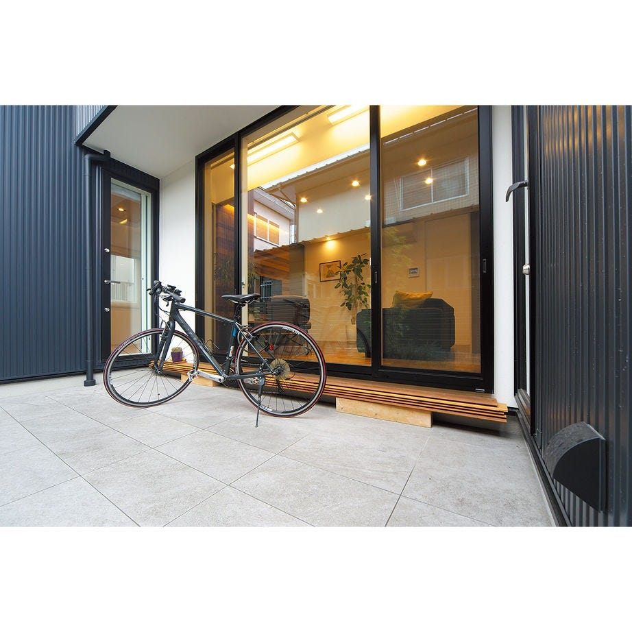 隣家との距離を取るために設けたテラス。自動車がディスプレイのように空間を引き立てる