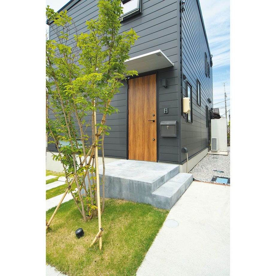 木目の扉が引き立つ玄関まわり。シンプルで飽きのこないデザインに仕上げられている