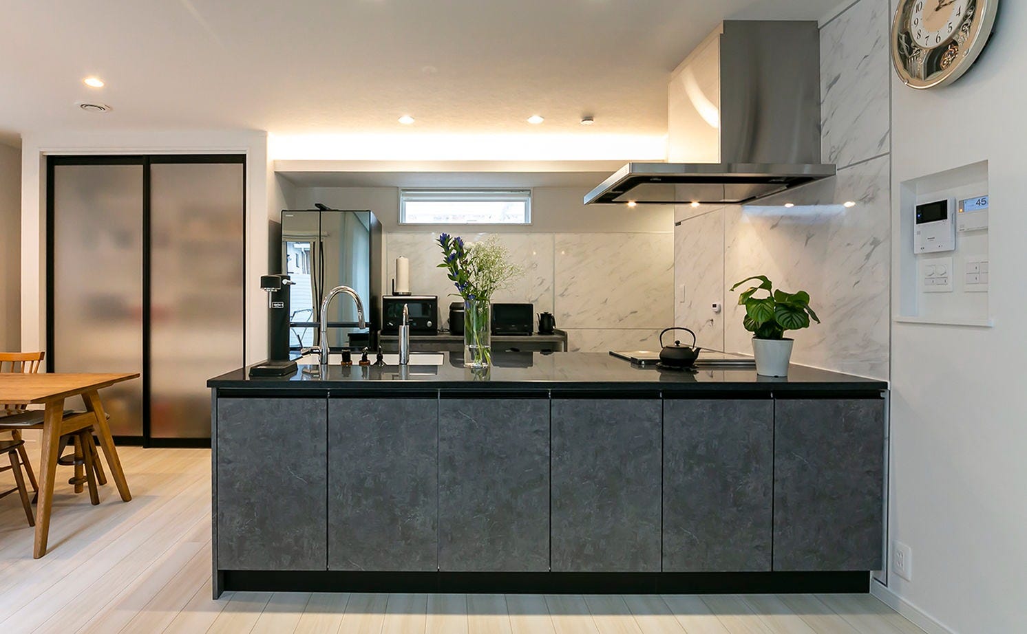 キッチンまわりは壁や床のホワイトに映える上質な黒系のカラーで統一している