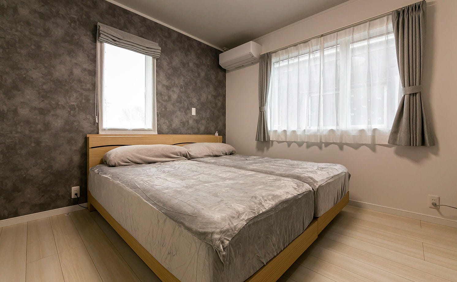 夫婦の寝室はアクセントクロスを採用し、シックで落ち着いたイメージに。二面採光で日中は明るい