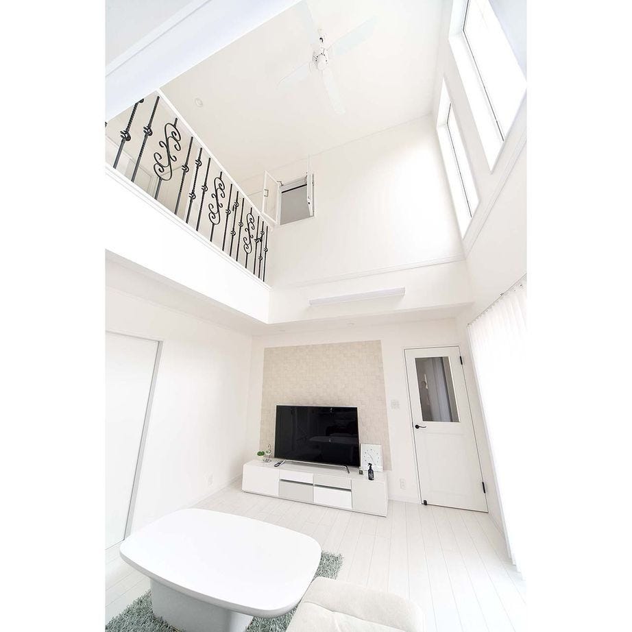 大きな吹抜けを設けたリビング。テレビの後ろの壁にはエコカラットを採用し、白い空間のアクセントに。ソファから見えるこの景色がSさんのお気に入り