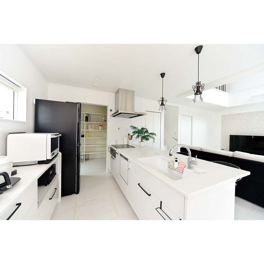 キッチンの面材も清潔感あふれる白に。キッチンの奥に設けられたパントリーは、保存食品等のストックに重宝している