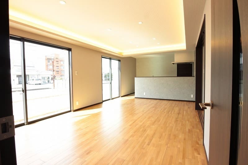 大きな窓から優しい光が差し込む広々としたLDK（リビングダイニングキッチン）。対面式キッチンのため料理をしながら家族と団欒ができる憩いの空間に仕上がっています。また、ご依頼主様のこだわりの天井の照明はLDK（リビングダイニングキッチン）を優しい光で包み込む設計になっています。