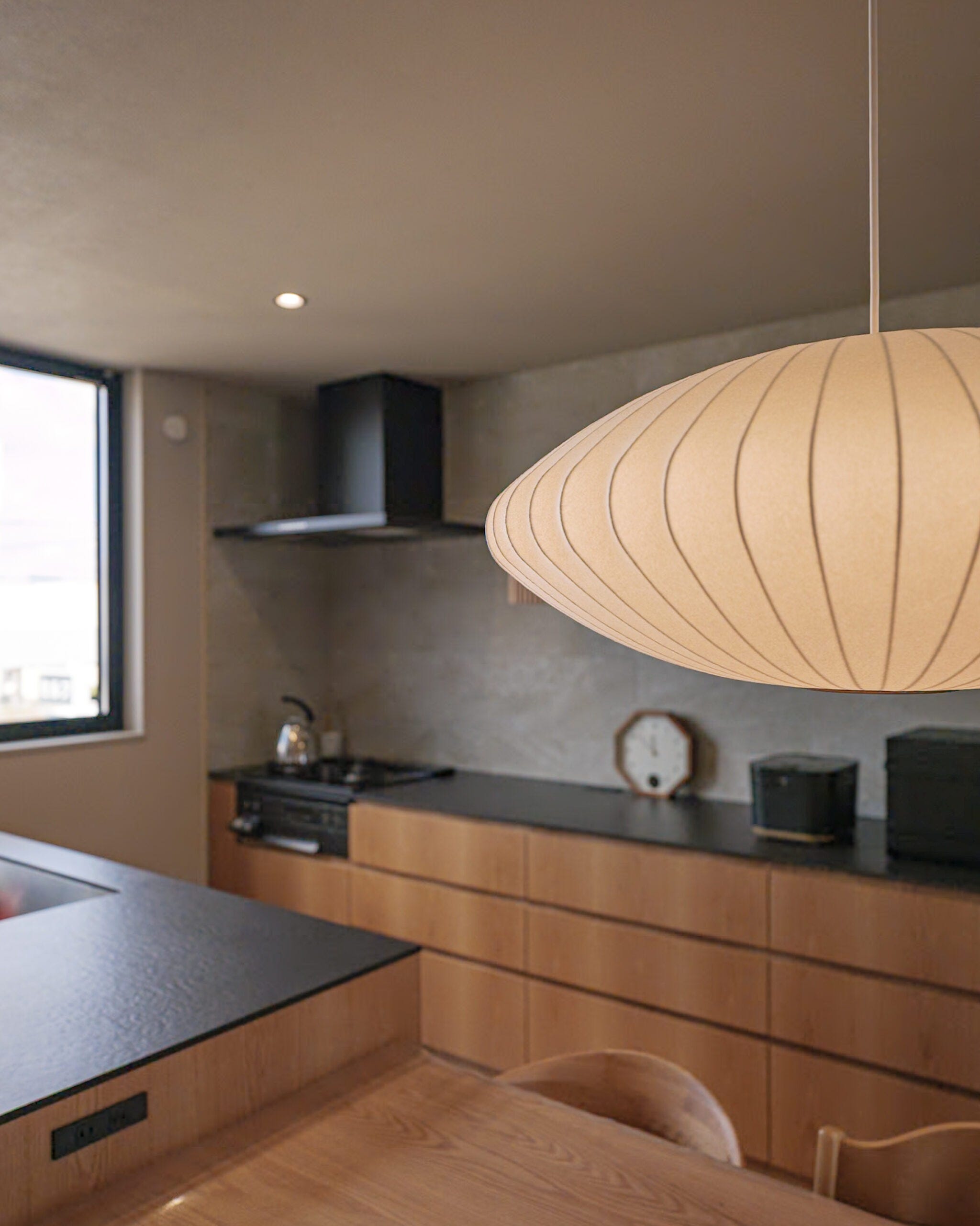 奥様こだわりの照明はお家の真ん中で家族を温かく見守ります。木の温もりに囲まれたキッチンに映えるお家を象徴するインテリアです。