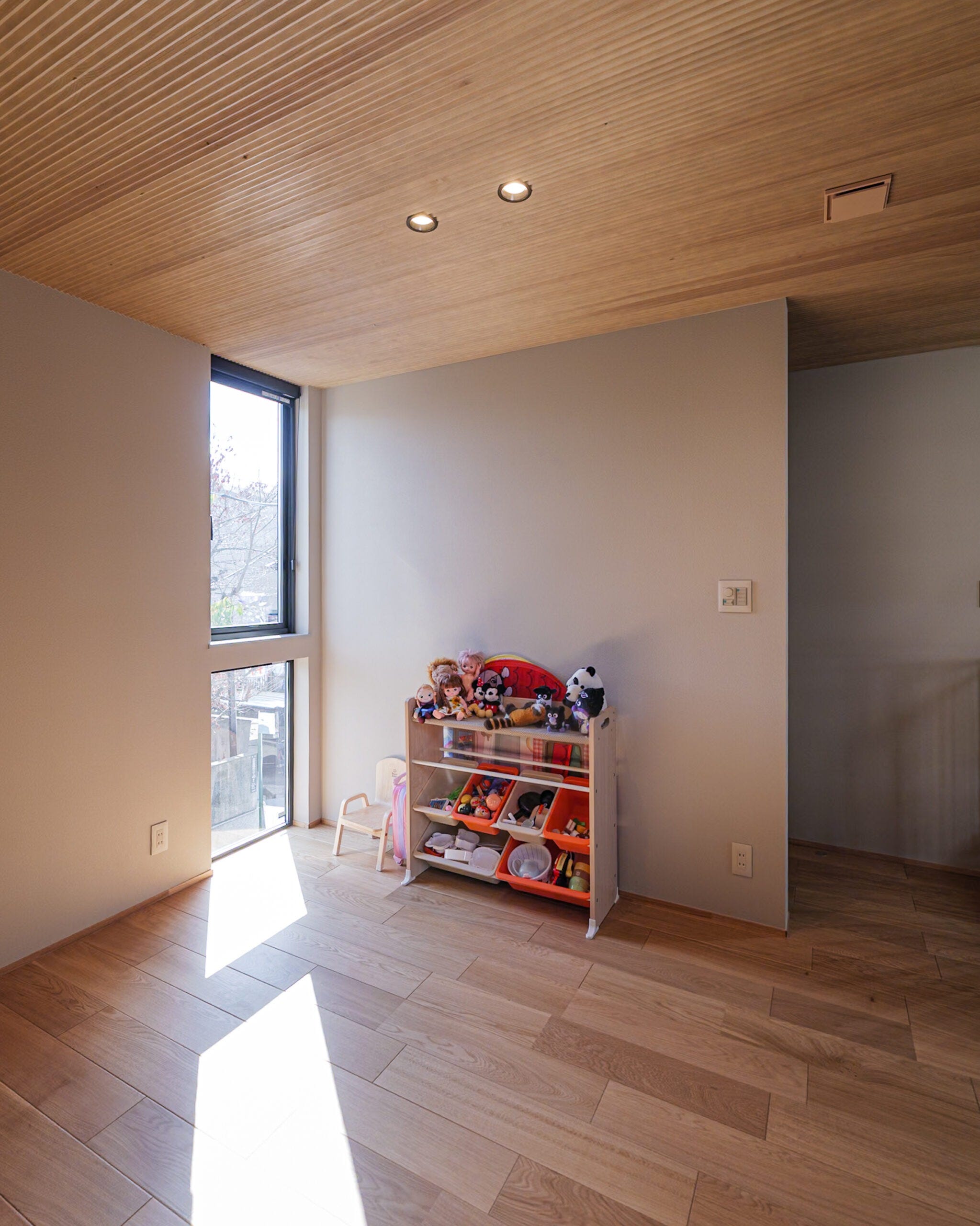 やわらかな光が差し込む、明るく心地よいフリースペース。木目が美しい天井と床がグレージュの空間に温もりを添え、のびやかで落ち着いた雰囲気に仕上がっています。お子さまの遊び場としても、家族のくつろぎの場所としても活躍する、家族団らんのスペースです。