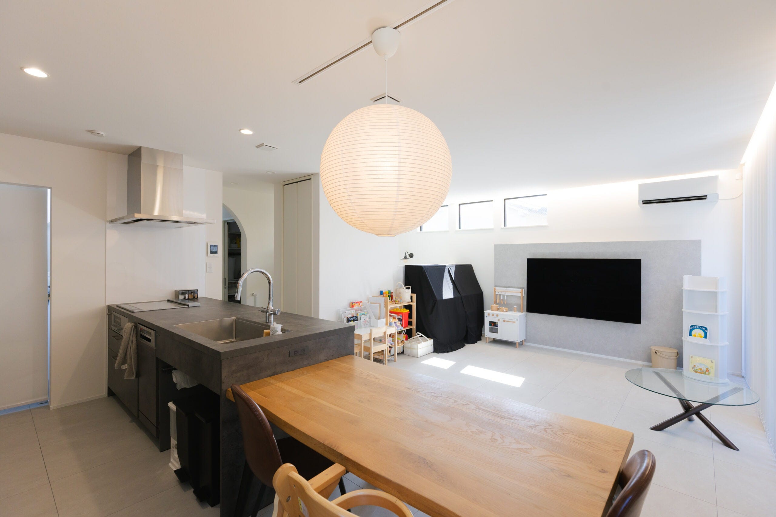 リビング全体を見渡せるキッチン。キッチンの横には横並びダイニングで家事ラクも叶える。白でまとめた空間にシックなカラーのグラフテクトキッチン。空間にメリハリを与えます。