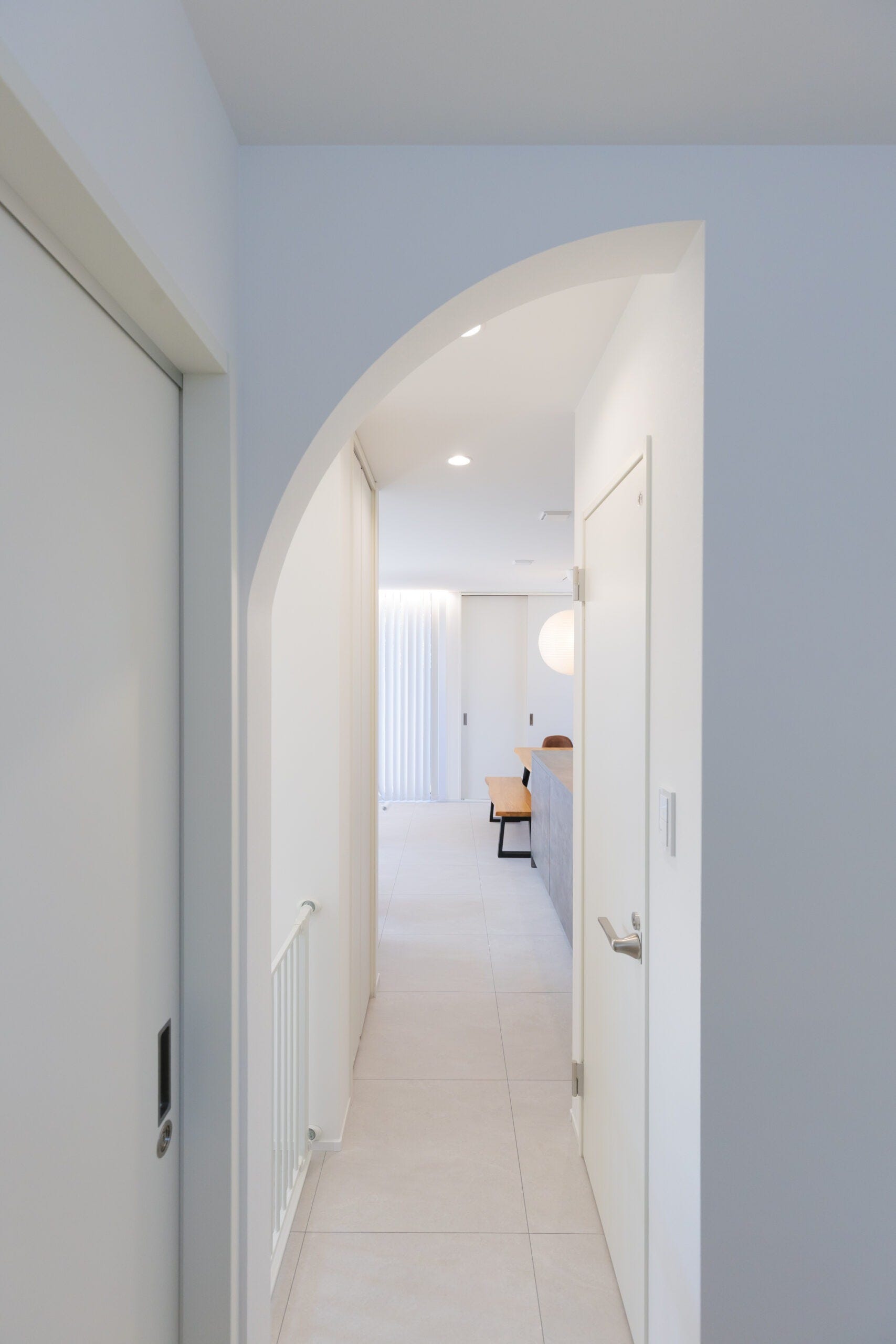 上部をアーチ型に仕上げた下がり壁は特別な空間への入り口。こちらの物件は、キッチン横に洗濯動線がある為、おしゃれに空間を仕切りたかったというお施主様のお気持ちにお答えする形で施工させて頂きました。