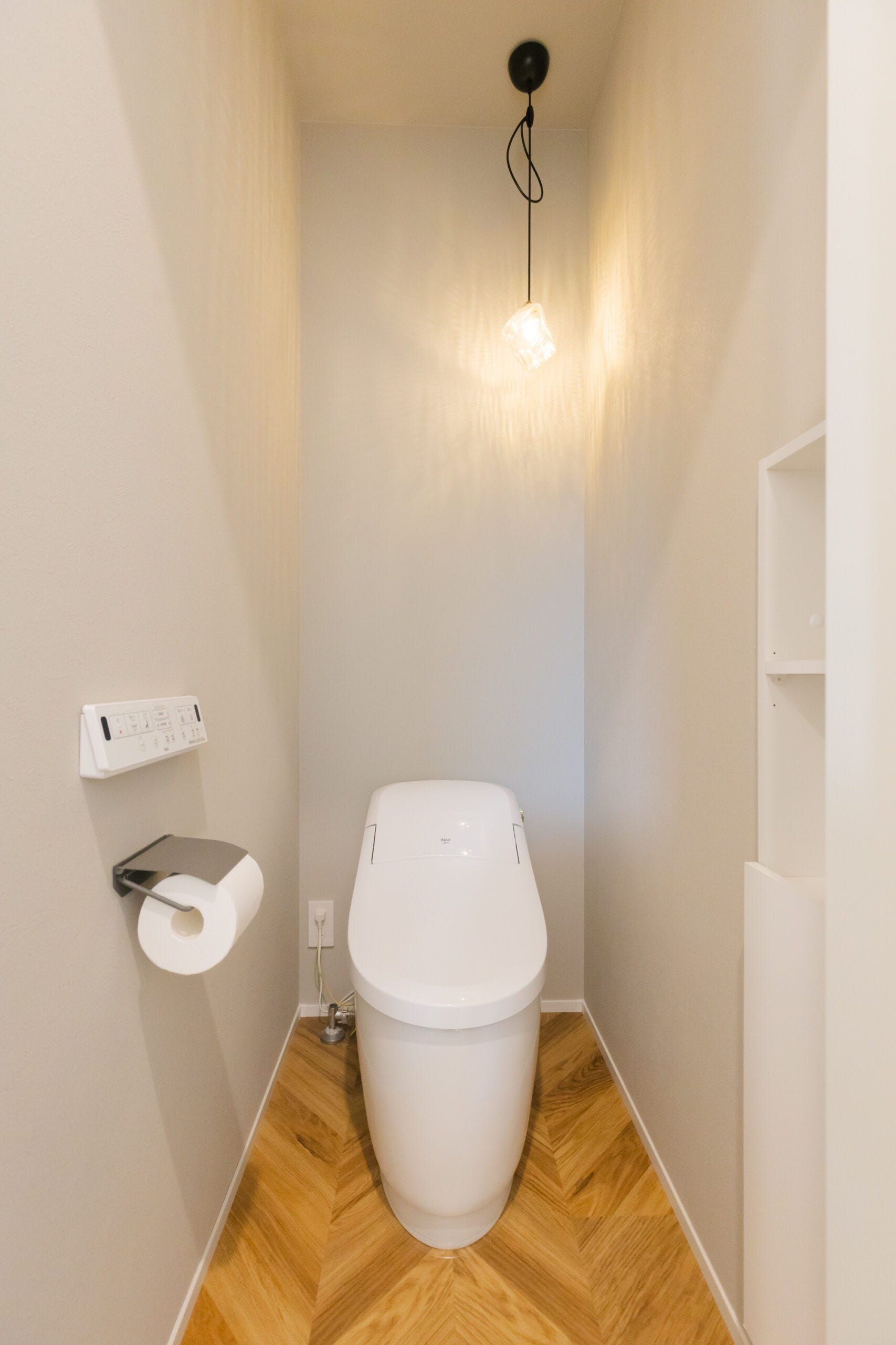 壁一面は落ち着いたトーンのホワイトで統一。床はヘリンボーン柄を採用し、落ち着きがありつつもアクセントのある空間へと仕上げました。収納も使いやすい位置を考えて設置しました。