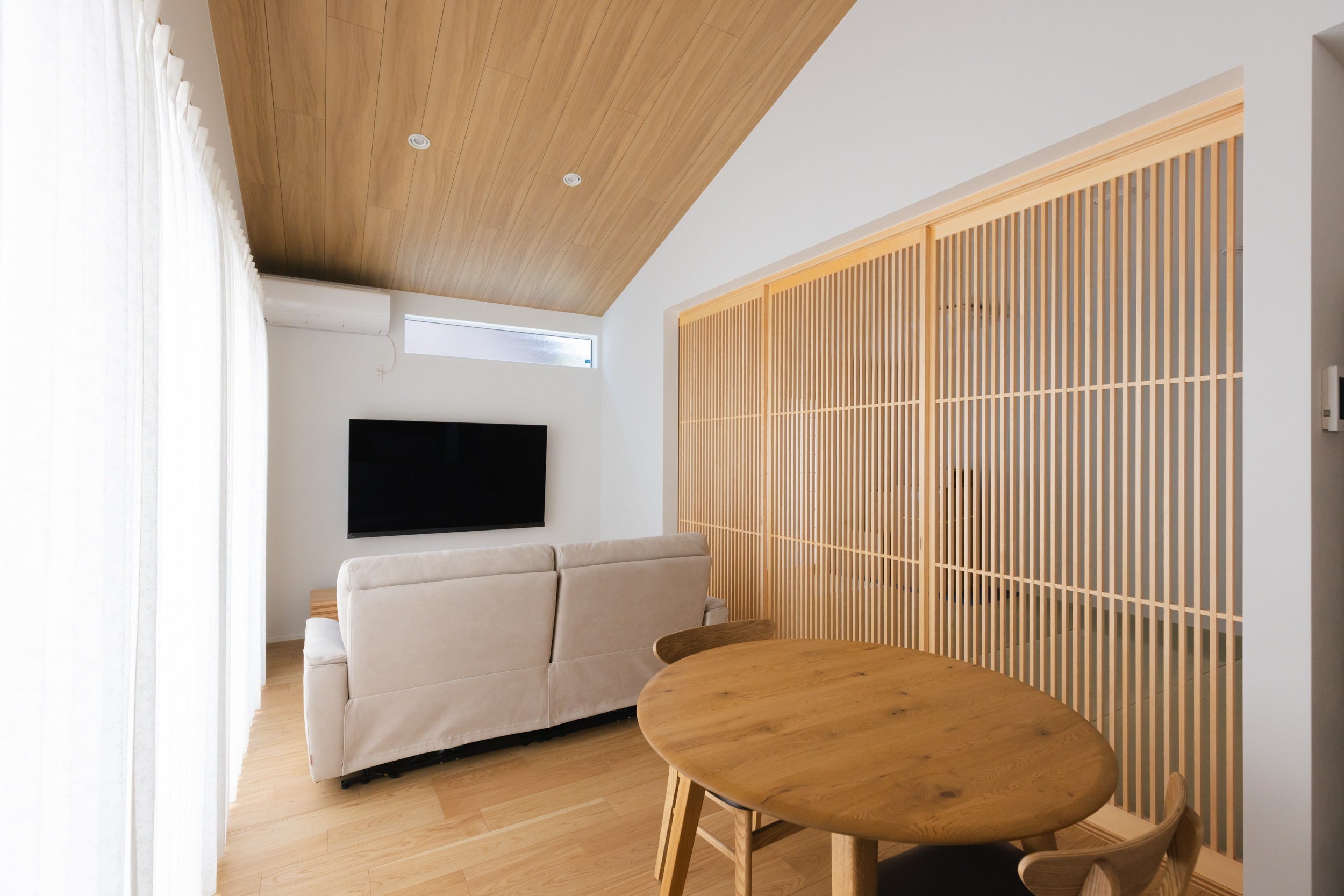 北欧カラーを感じさせる明るい配色に、親世帯様こだわりの3枚扉引戸が「和」の良さを更に引き立てる。左側には子世帯と繋がる大きな掃き出し窓で、お昼でも充分明るく感じられる。