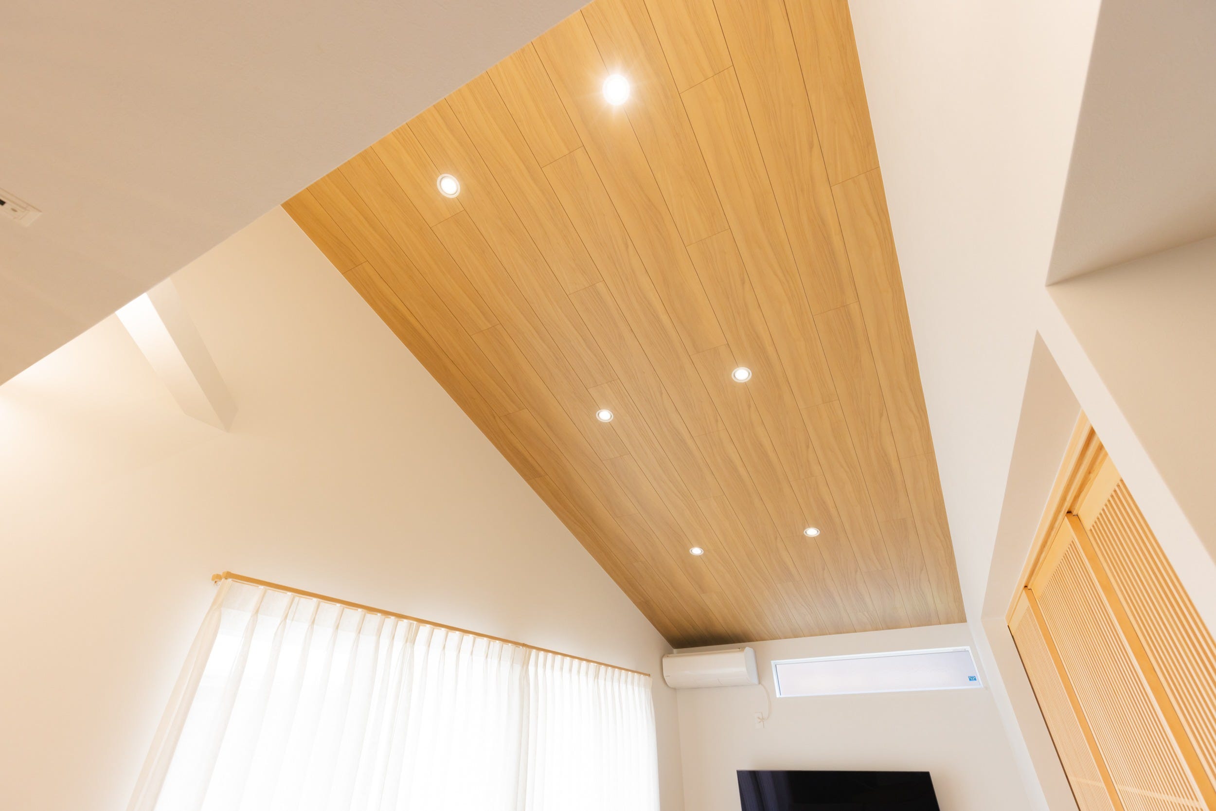 高めに設計した勾配天井には木製洋室天井「シエロシーリング」を施工。床からの高さは約4mの高さ!親世帯側は平屋仕様ですが高さもあるのでとても広く感じられます。