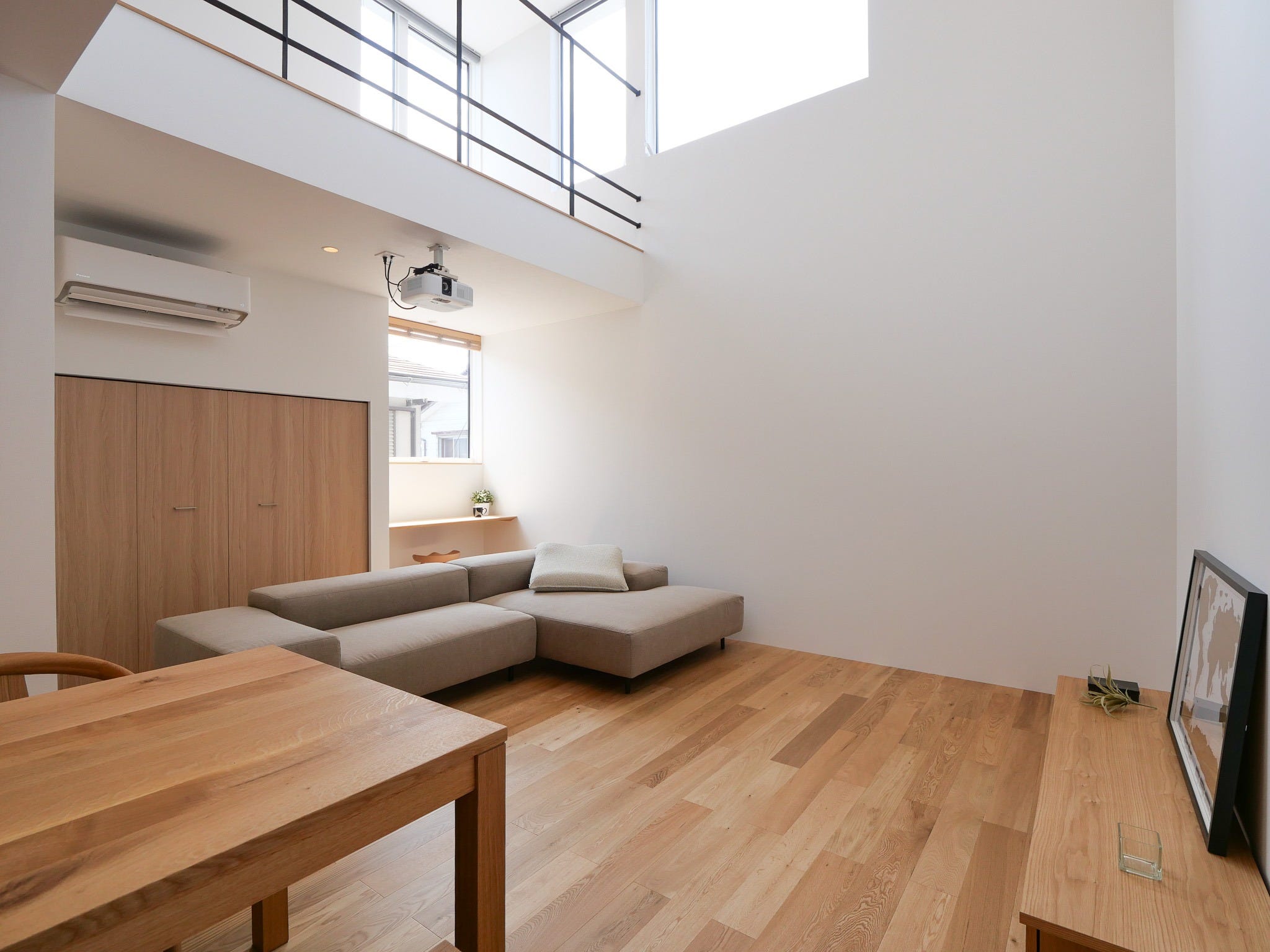 狭小地でも広々と過ごす。吹抜けで大きなスクリーンを楽しむ住まい