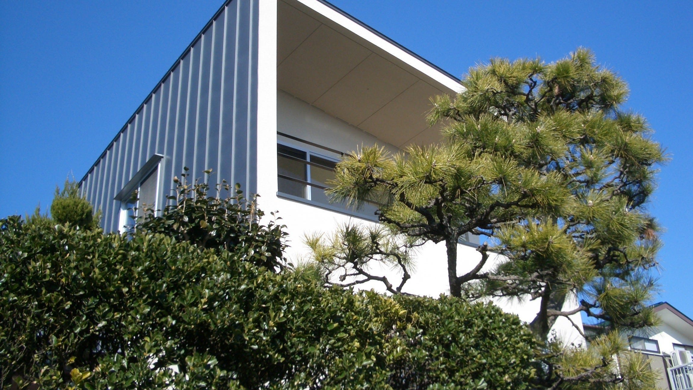 実家の隣に建てた終の棲家 ■ 城山の家 (小田原の街を一望に見下ろす高台に建つ家。街の向こうには相模湾を望み、晴れた日なら、遠く大島さえ見えるロケーション。
そんな場所に建てた家は、御実家の敷地を二つに分け、御実家に住まれる御母堂様に対して「味噌汁が冷めない距離」よりも、近くに寄り添う事が目的でした。建物は27坪と言う比較的ゆったりとした広さですが、間取りで言えば「1LDK」。そんな家は全ての部屋が広く、ゆったりと造られています。)