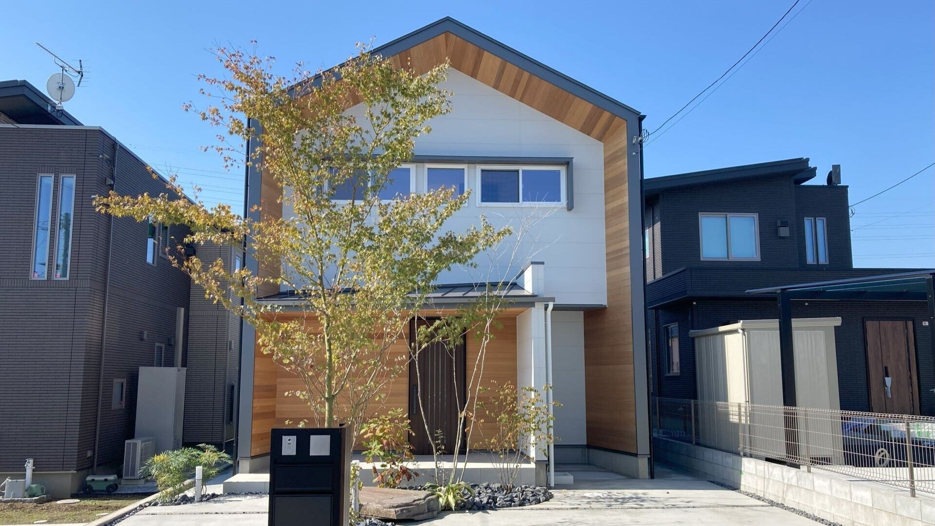 塚原の家■家事動線を繋げた回遊動線を持つ家 (東西に長い敷地に建つ2LDKの家。ベッドルームの他に、玄関に広いシューズ・クローゼット、台所脇にはパントリーと家事室を設けています。またリモート・ワークに使う書斎も設けているため、寝室の数だけを基準とした「2LDK」と表す以上の広さとゆとりを確保しています。敷地東側に道路、西側には高さ約2mののり面があり、その部分は庭などに活用できません。その上、北側斜線の制限を受けるため、建物の配置計画及び外部との繋がり方が計画のポイントとなりました。)